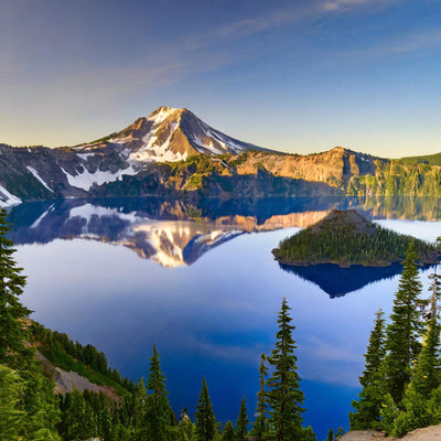 Deep blue lake surrounded by towering cliffs and lush forests at Crater Lake National Park, Oregon