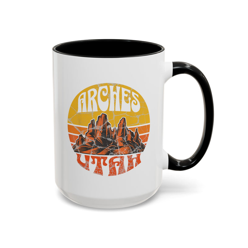 15 oz black ceramic mug with a contrasting handle and interior, featuring a vibrant design of Arches National Park in Utah, showcasing the park's iconic rock formations.