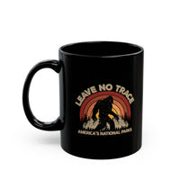 Bigfoot souvenir mug with "Leave No Trace" text and America's National Parks scene featuring a colorful sunset background.