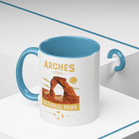 White 11 oz ceramic coffee mug with a light blue handle, featuring a detailed design of Arches National Park, Utah. Perfect for coffee or tea lovers.