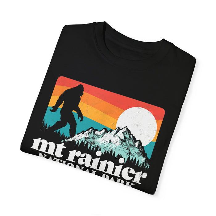 T-shirt featuring a retro design with a silhouette of Bigfoot, a mountain, and the text "Mt Rainier National Park."