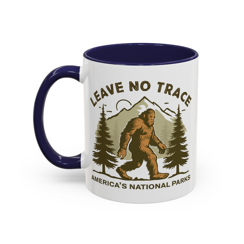 11 oz navy Bigfoot souvenir mug with "Leave No Trace" text, trees, and mountains in the background, from America's National Parks.