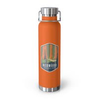 Orange stainless steel water bottle featuring a design of Redwood National Park with towering redwood trees.