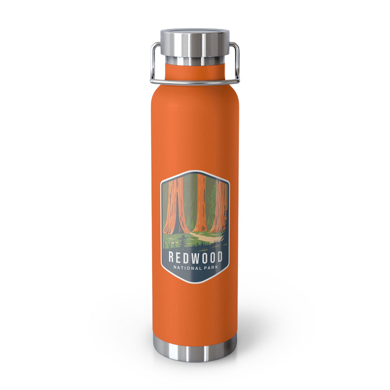 Orange stainless steel water bottle featuring a design of Redwood National Park with towering redwood trees.