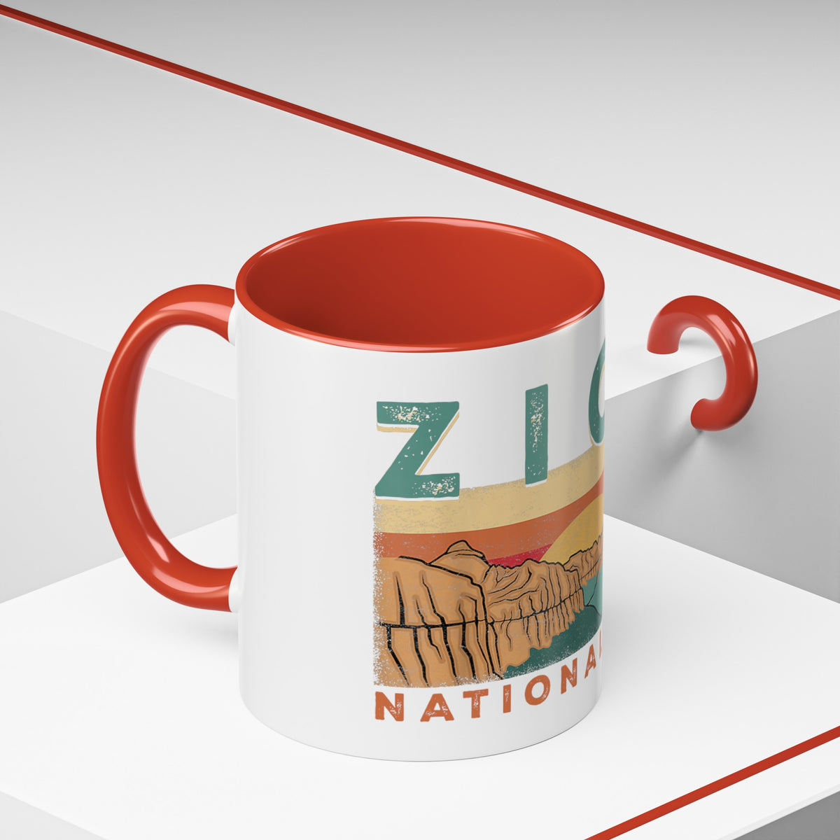 White ceramic mug with contrasting handle and interior, featuring a sunset landscape design of Zion National Park.