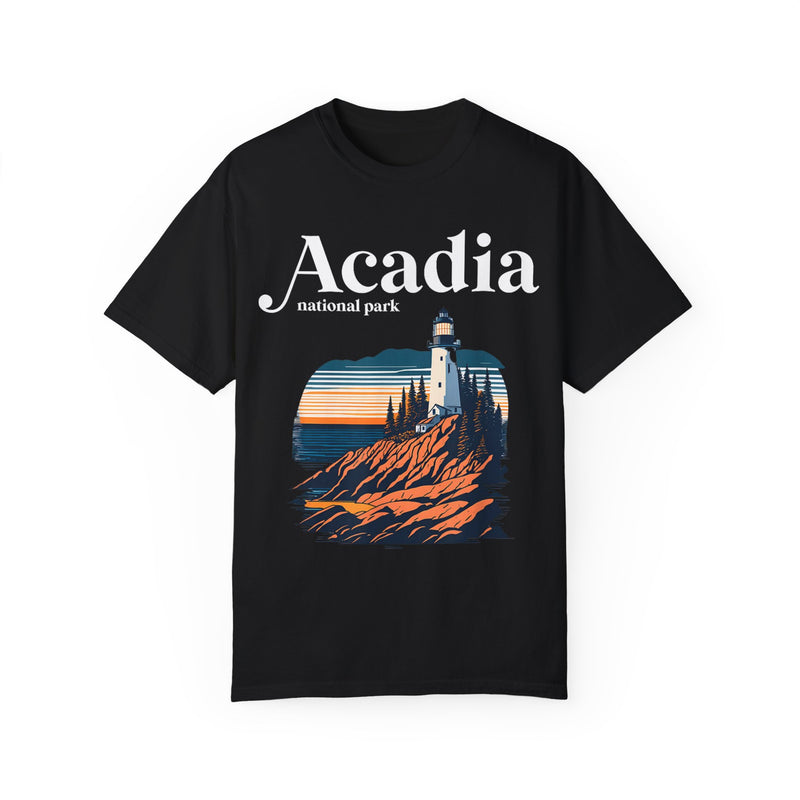 Acadia National Park T-shirt featuring a graphic design with a lighthouse, rocky cliffs, and sunset, with "Acadia" text.