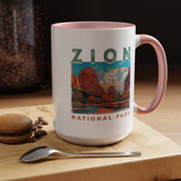 White ceramic mug with a contrasting handle and interior, featuring a scenic landscape design of Zion National Park.