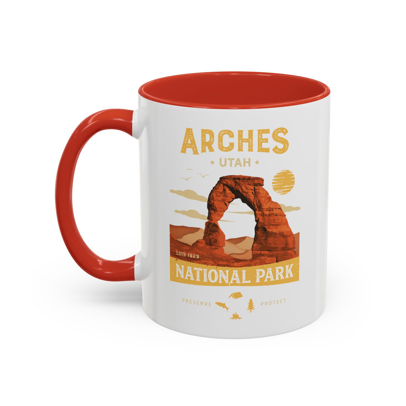 White 11 oz ceramic coffee mug with a red handle, featuring a detailed design of Arches National Park, Utah. Perfect for coffee or tea lovers.