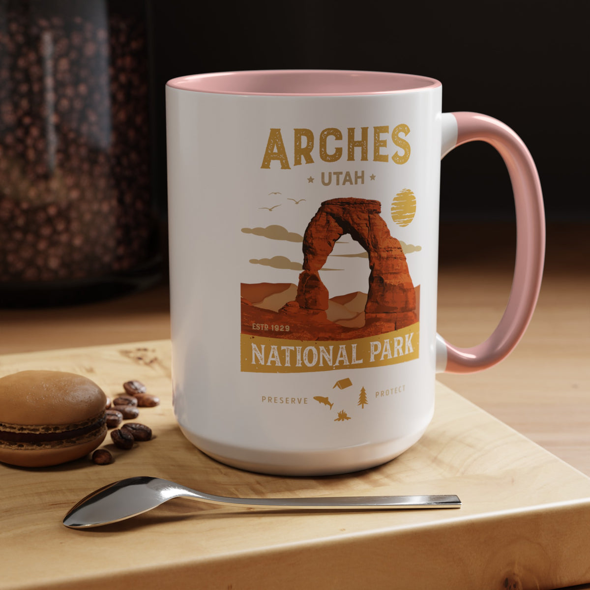 White 15 oz ceramic coffee mug with a pink handle, featuring a detailed design of Arches National Park, Utah. Perfect for coffee or tea lovers.