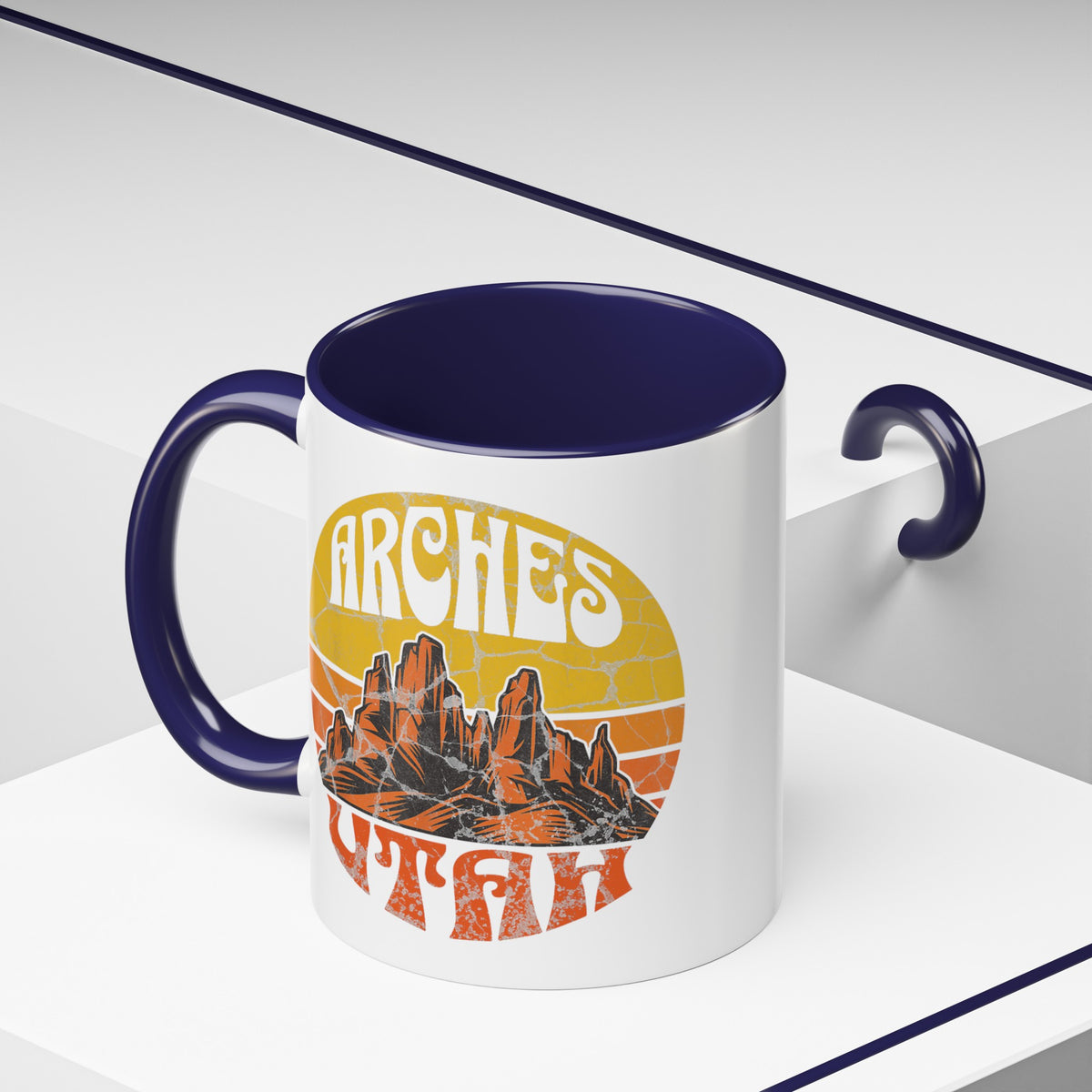 11 oz navy ceramic mug with a contrasting handle and interior, featuring a vibrant design of Arches National Park in Utah, showcasing the park's iconic rock formations.