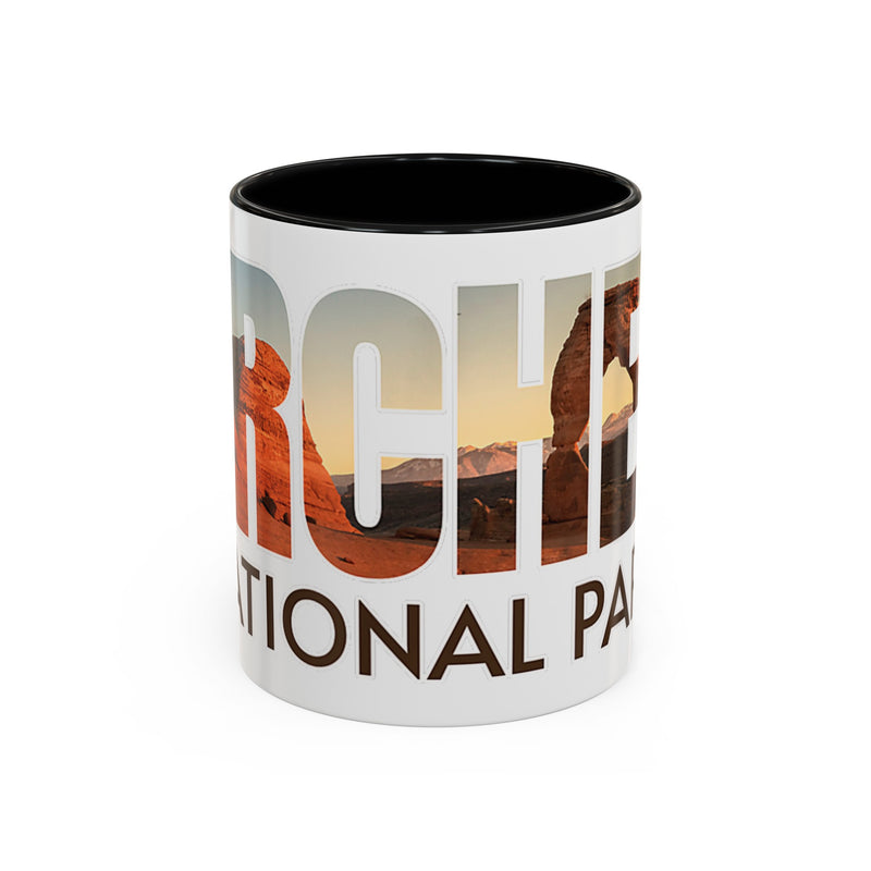 White 11 oz ceramic coffee mug with a black handle, featuring a scenic design of Arches National Park, Utah. Perfect for coffee or tea lovers.