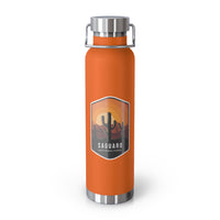 Orange stainless steel water bottle featuring a design of Saguaro National Park with cactus and sunset scenery.