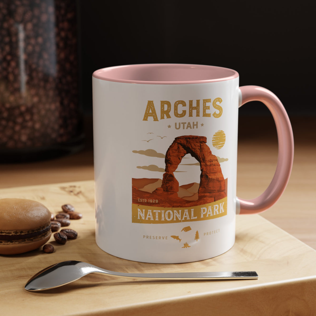 White 11 oz ceramic coffee mug with a pink handle, featuring a detailed design of Arches National Park, Utah. Perfect for coffee or tea lovers.