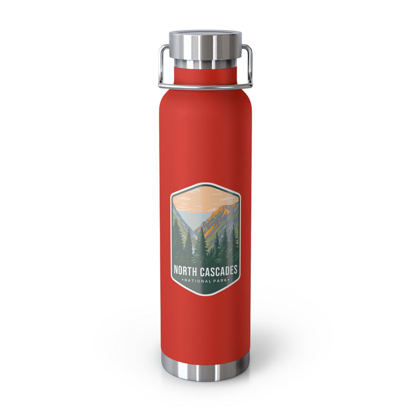 A red double-wall stainless steel water bottle featuring a scenic design inspired by North Cascades National Park, showcasing mountains and pine trees.