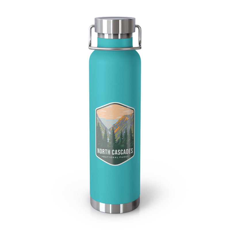 A mint green double-wall stainless steel water bottle featuring a scenic design inspired by North Cascades National Park, showcasing mountains and pine trees.