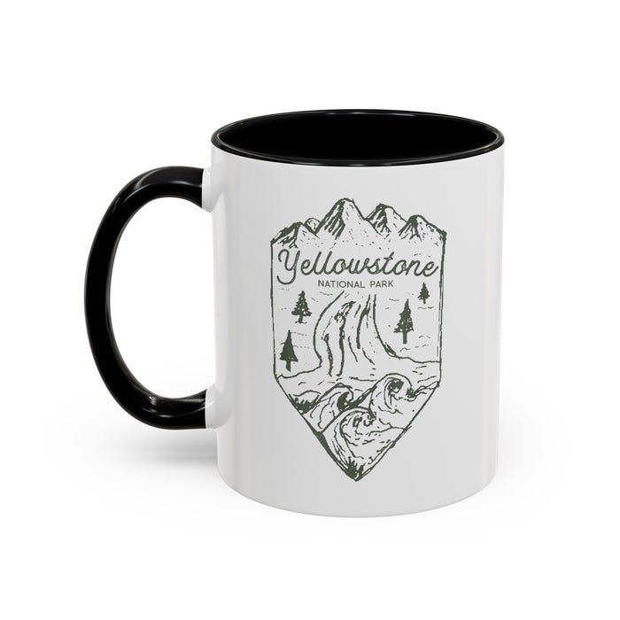 White ceramic mug with a contrasting handle and interior, featuring a minimalist design of Yellowstone National Park with mountains, trees, and a river.