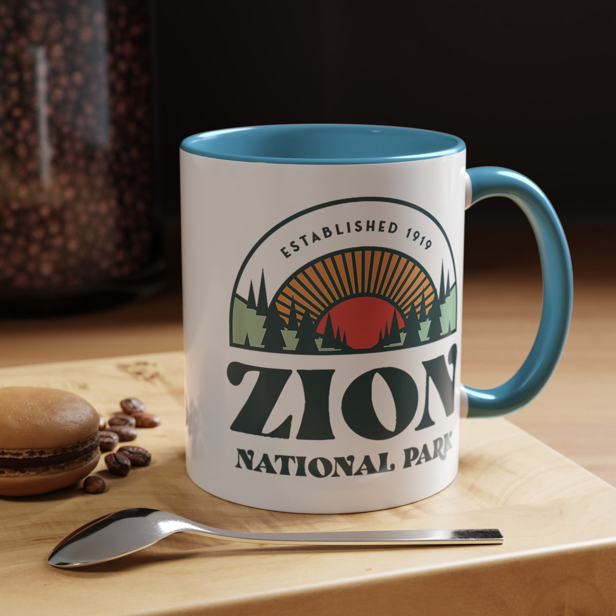 11 oz ceramic mug with light blue contrasting handle featuring an established 1919 design of Zion National Park, perfect as a souvenir.