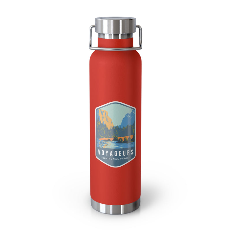 Red stainless steel water bottle featuring a design of Voyageurs National Park with a lake and forest scenery.