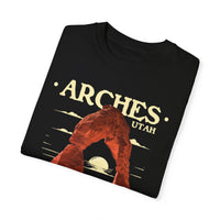 T-shirt featuring a scenic design of Arches National Park in Utah with a prominent arch and sunset background.