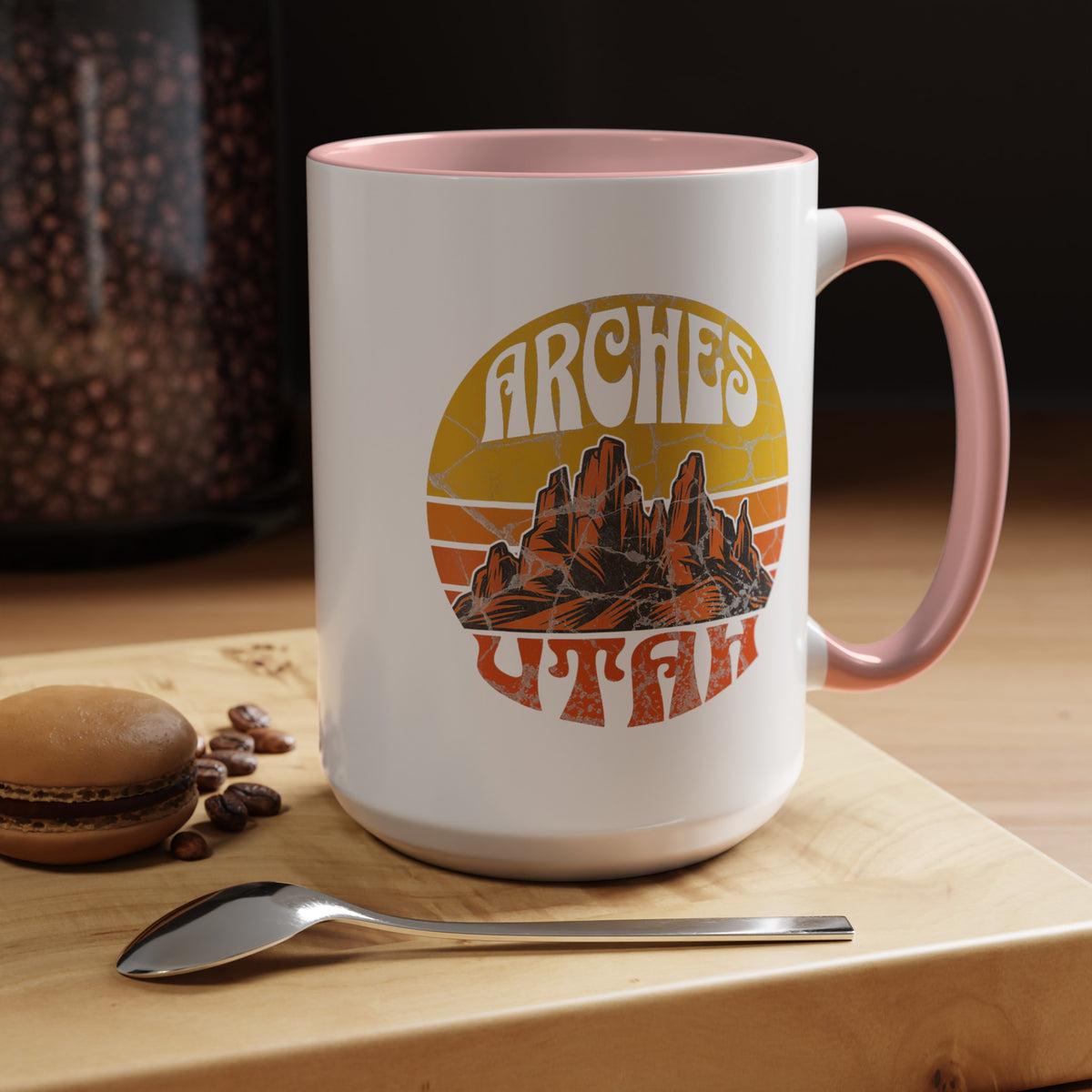 15 oz pink ceramic mug with a contrasting handle and interior, featuring a vibrant design of Arches National Park in Utah, showcasing the park's iconic rock formations.