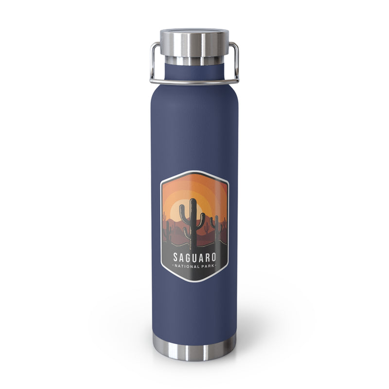 Navy stainless steel water bottle featuring a design of Saguaro National Park with cactus and sunset scenery.