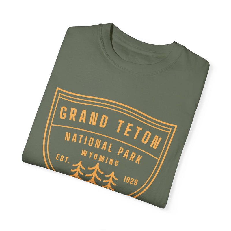 Grand Teton National Park T-shirt featuring a shield graphic design with trees and "Est. 1929 Wyoming" text.