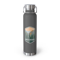 A grey double-wall stainless steel water bottle featuring a scenic design inspired by North Cascades National Park, showcasing mountains and pine trees.