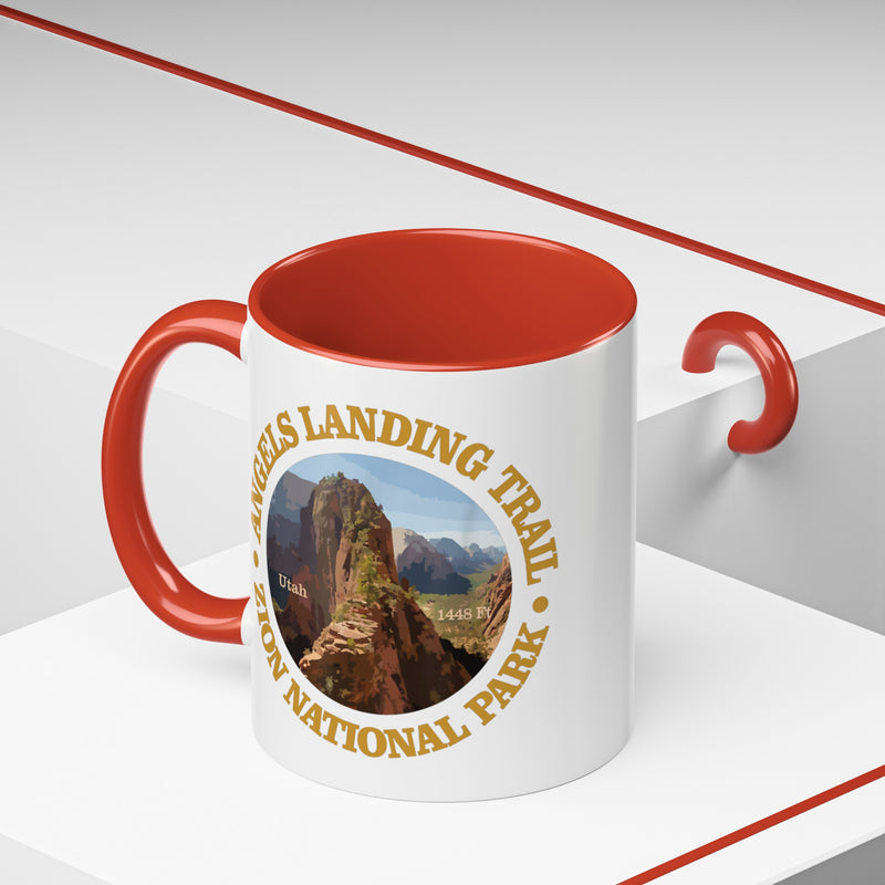 White ceramic mug with a contrasting handle and interior, featuring an image of Angels Landing Trail in Zion National Park with a mountain landscape design.