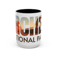 White 15 oz ceramic coffee mug with a black handle, featuring a scenic design of Arches National Park, Utah. Perfect for coffee or tea lovers.