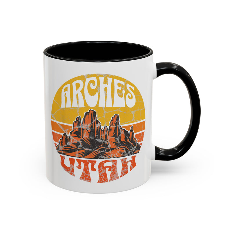 11 oz black ceramic mug with a contrasting handle and interior, featuring a vibrant design of Arches National Park in Utah, showcasing the park's iconic rock formations.