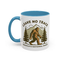 11 oz light blue Bigfoot souvenir mug with "Leave No Trace" text, trees, and mountains in the background, from America's National Parks.