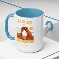 White 15 oz ceramic coffee mug with a light blue handle, featuring a detailed design of Arches National Park, Utah. Perfect for coffee or tea lovers.