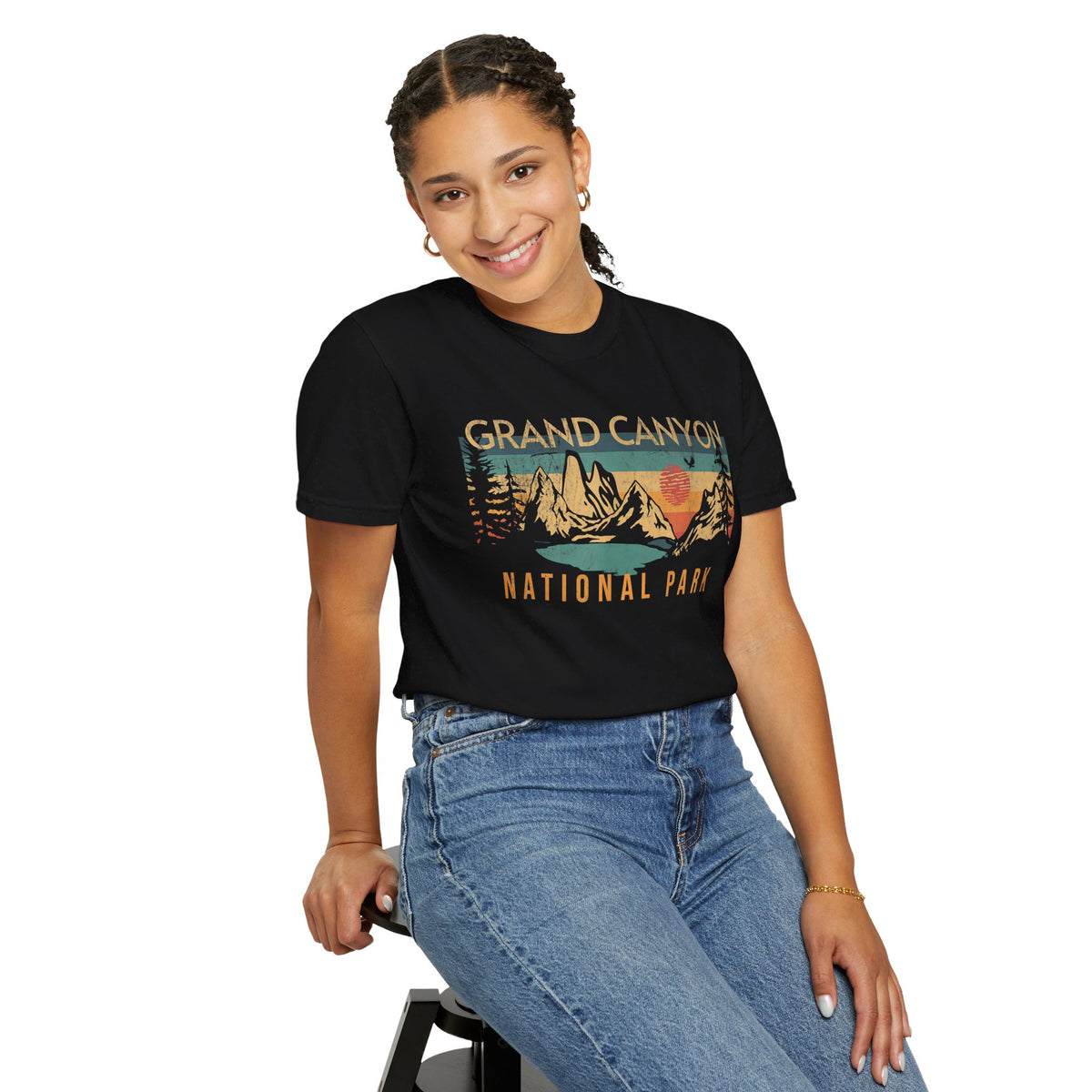 Grand Canyon National Park T-shirt featuring a scenic sunrise graphic design with mountains and trees, modeled by a woman.