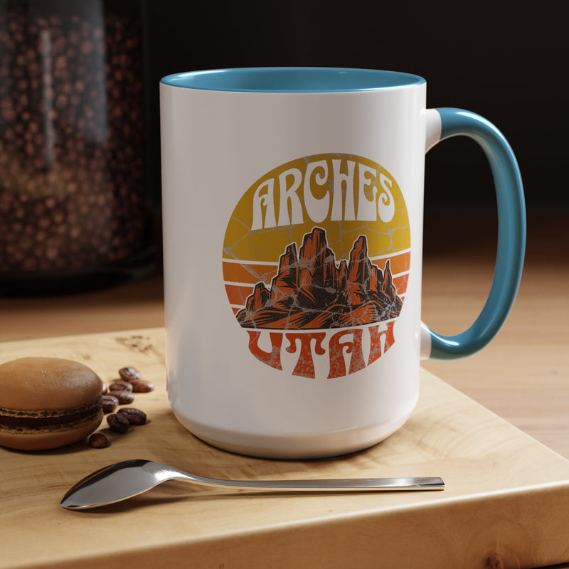 15 oz light blue ceramic mug with a contrasting handle and interior, featuring a vibrant design of Arches National Park in Utah, showcasing the park's iconic rock formations.