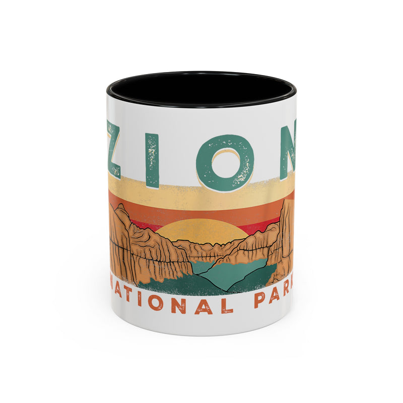 White ceramic mug with contrasting handle and interior, featuring a sunset landscape design of Zion National Park.