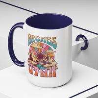 White ceramic mug with a contrasting handle and interior, featuring a colorful scenic design of Arches National Park in Utah.