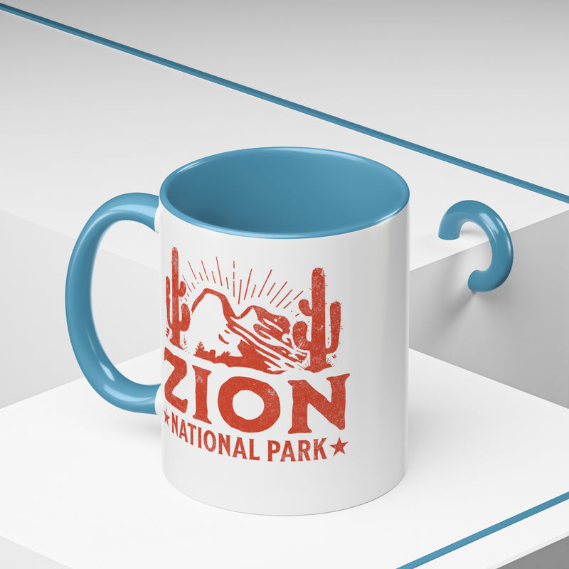 11 oz ceramic mug with light blue contrasting handle featuring a cactus design of Zion National Park, perfect as a souvenir.