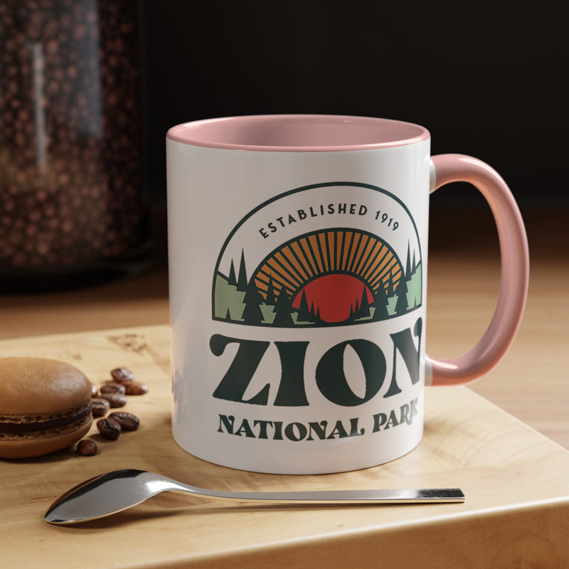 11 oz ceramic mug with pink contrasting handle featuring an established 1919 design of Zion National Park, perfect as a souvenir.