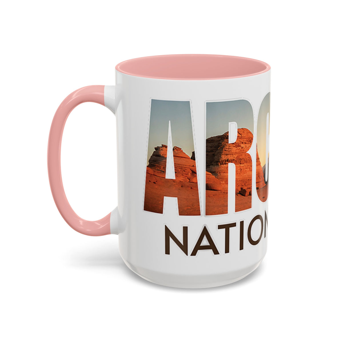 White 15 oz ceramic coffee mug with a pink handle, featuring a scenic design of Arches National Park, Utah. Perfect for coffee or tea lovers.