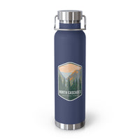 A navy double-wall stainless steel water bottle featuring a scenic design inspired by North Cascades National Park, showcasing mountains and pine trees.