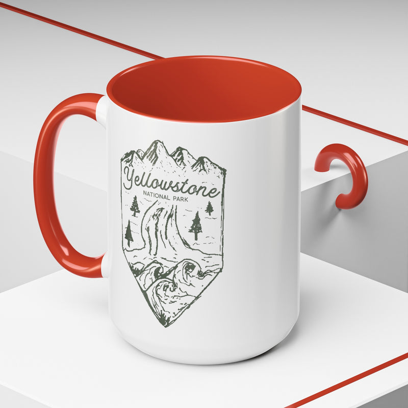 White ceramic mug with a contrasting handle and interior, featuring a minimalist design of Yellowstone National Park with mountains, trees, and a river.